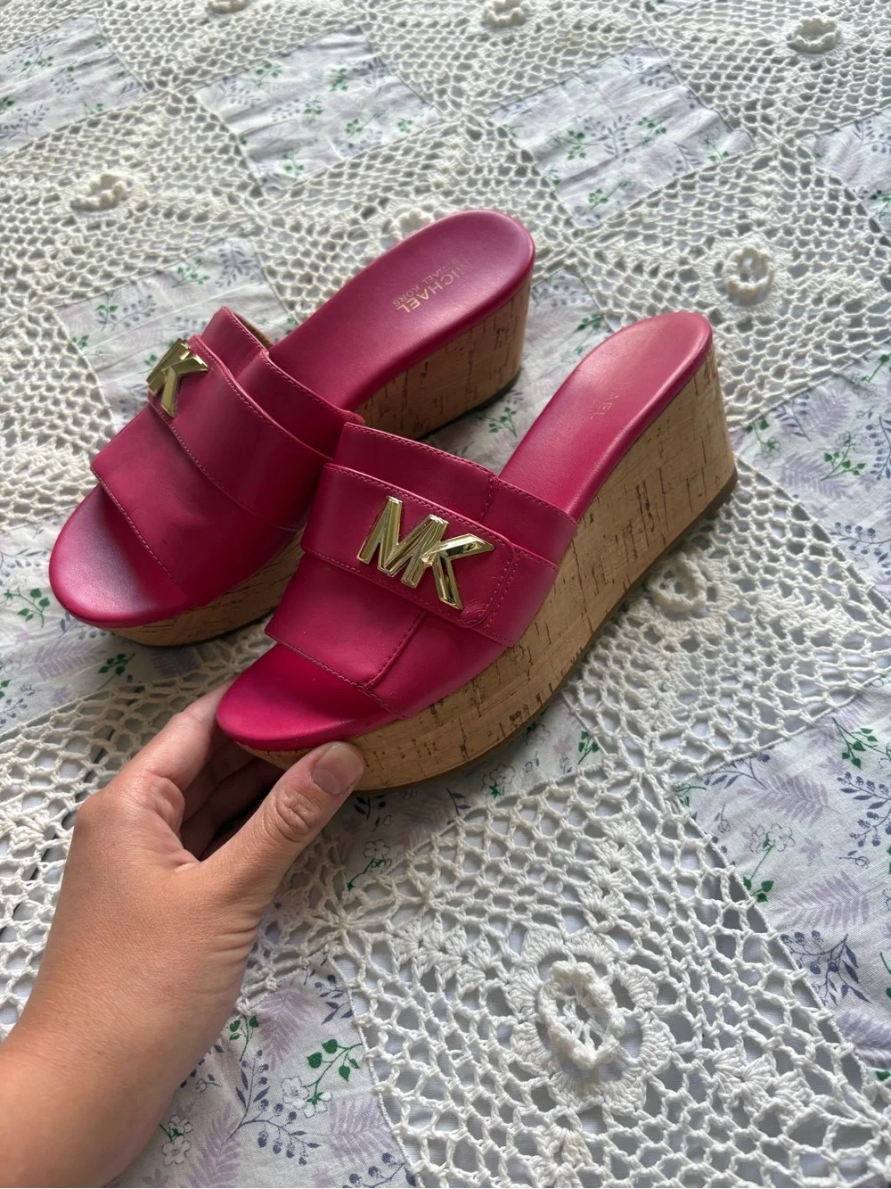 Michael Kors bright pink platform slide sandals with a cork wedge.